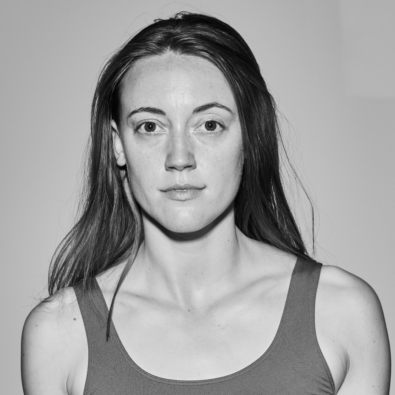 Black and white headshot of Noelle, a slender, fair-skinned white woman, with long hair