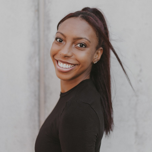 Kyra Laster - Smiling black woman with brown eyes and long hair