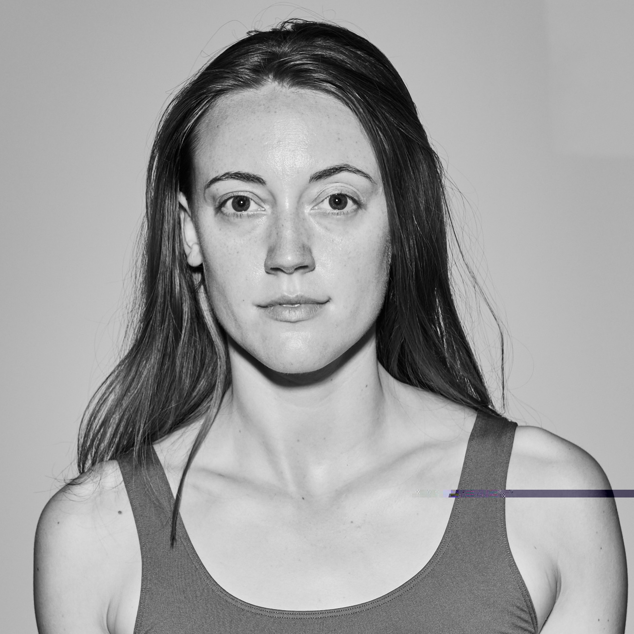 Black and white headshot of Noelle, a slender, fair-skinned, white woman with long light brown hair 