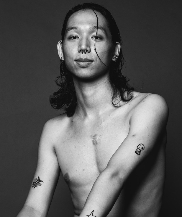 Black and white headshot of Ben, a tall and lean, asian american with shoulder length wavy black hair